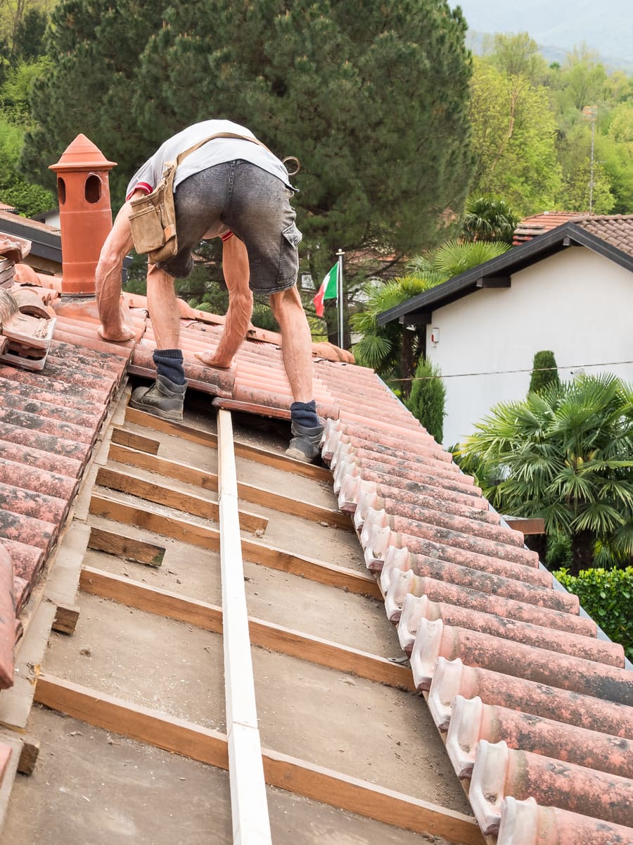 Roofer laying new tiles on a pitched roof
